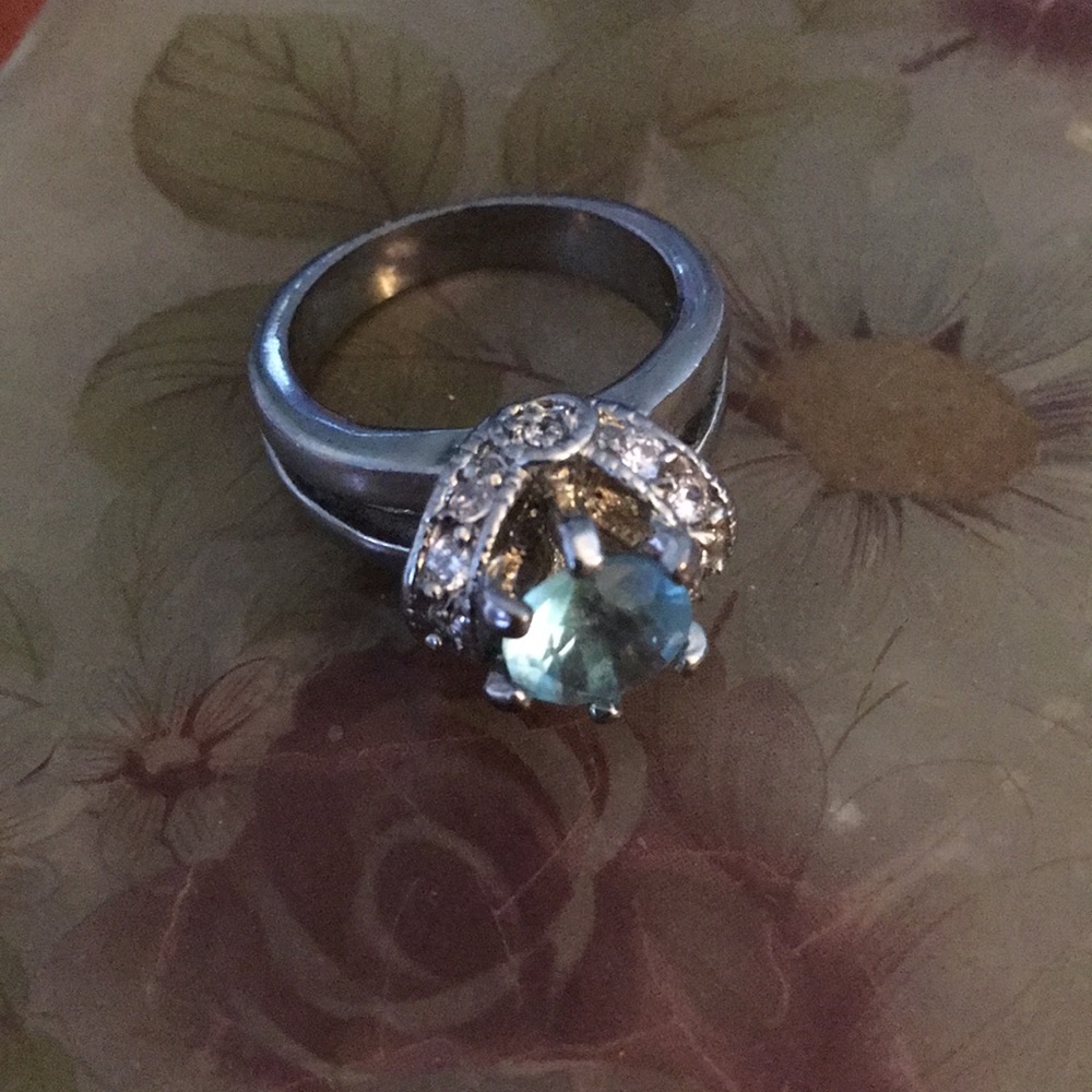 A tall blue stoned silver band ring.